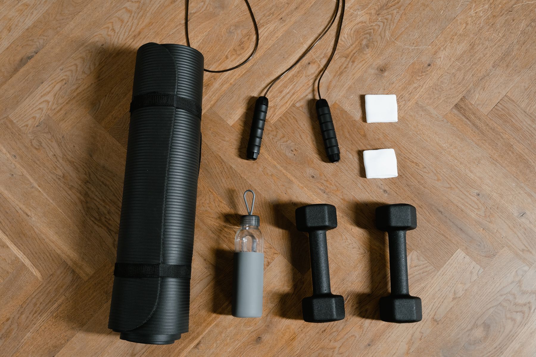 Illustrative exercise mat, dumbbells and water bottle